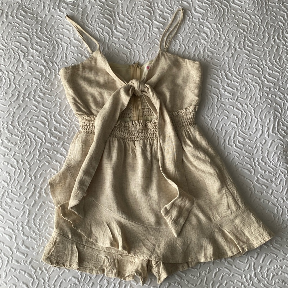 Cute linen lined romper with ruffle hem and skirt front.